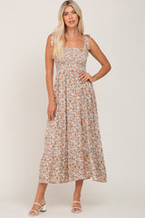 woman wearing a floral maxi dress with square neckline and tie shoulder straps