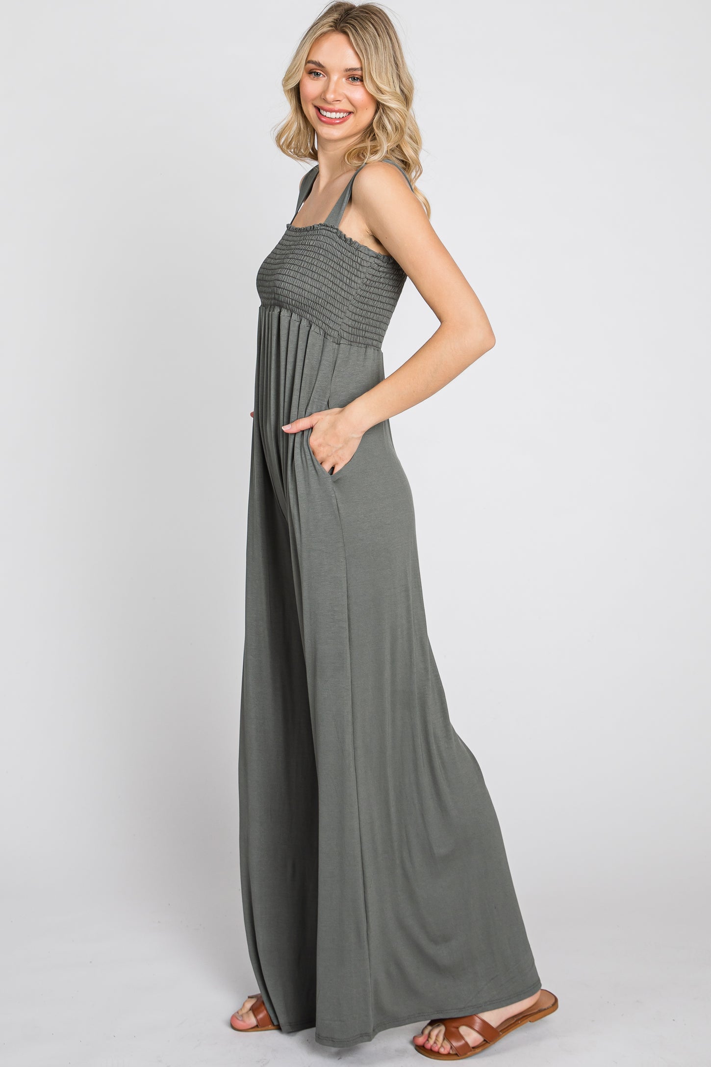 woman wearing a green maxi dress with a smocked bodice and side pockets