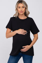 woman wearing a black maternity t-shirt and holding her baby bump