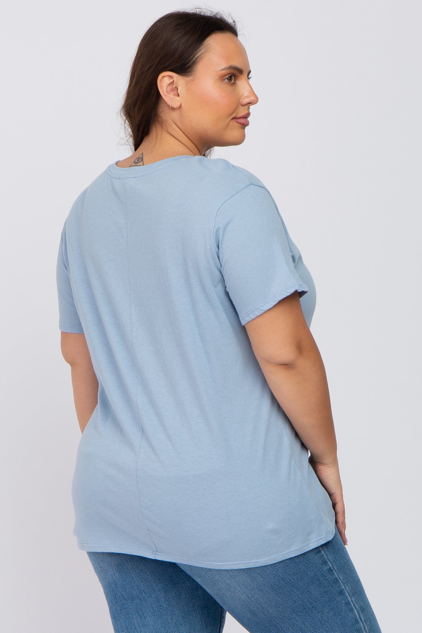 woman wearing a light blue short sleeve t-shirt and denim jeans viewed from the back