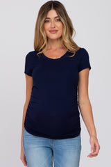woman wearing a navy blue short sleeve maternity top with ruching details and a visible baby bump