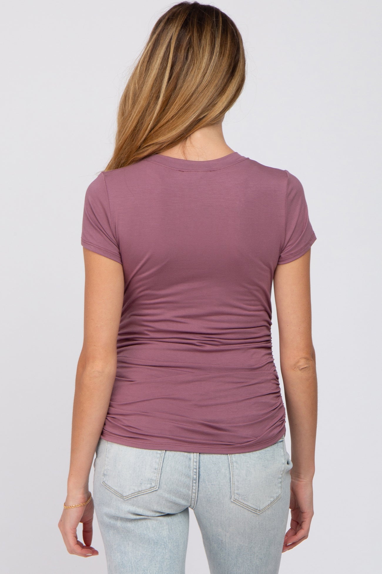 woman wearing a mauve maternity top with gathered sides, viewed from the back