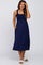 woman wearing a navy blue maternity dress with a smocked bodice and pockets, showing her baby bump