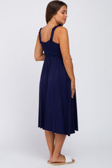 woman wearing a navy blue maternity dress with smocked bodice and flowy skirt, showcasing her baby bump from the back