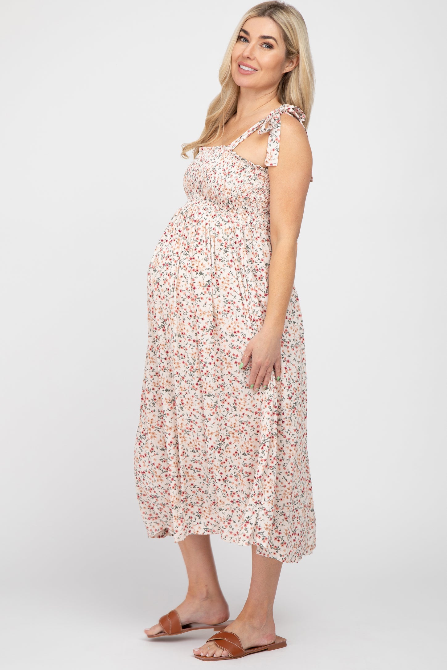 woman wearing a floral maternity dress with tie straps and a baby bump visible