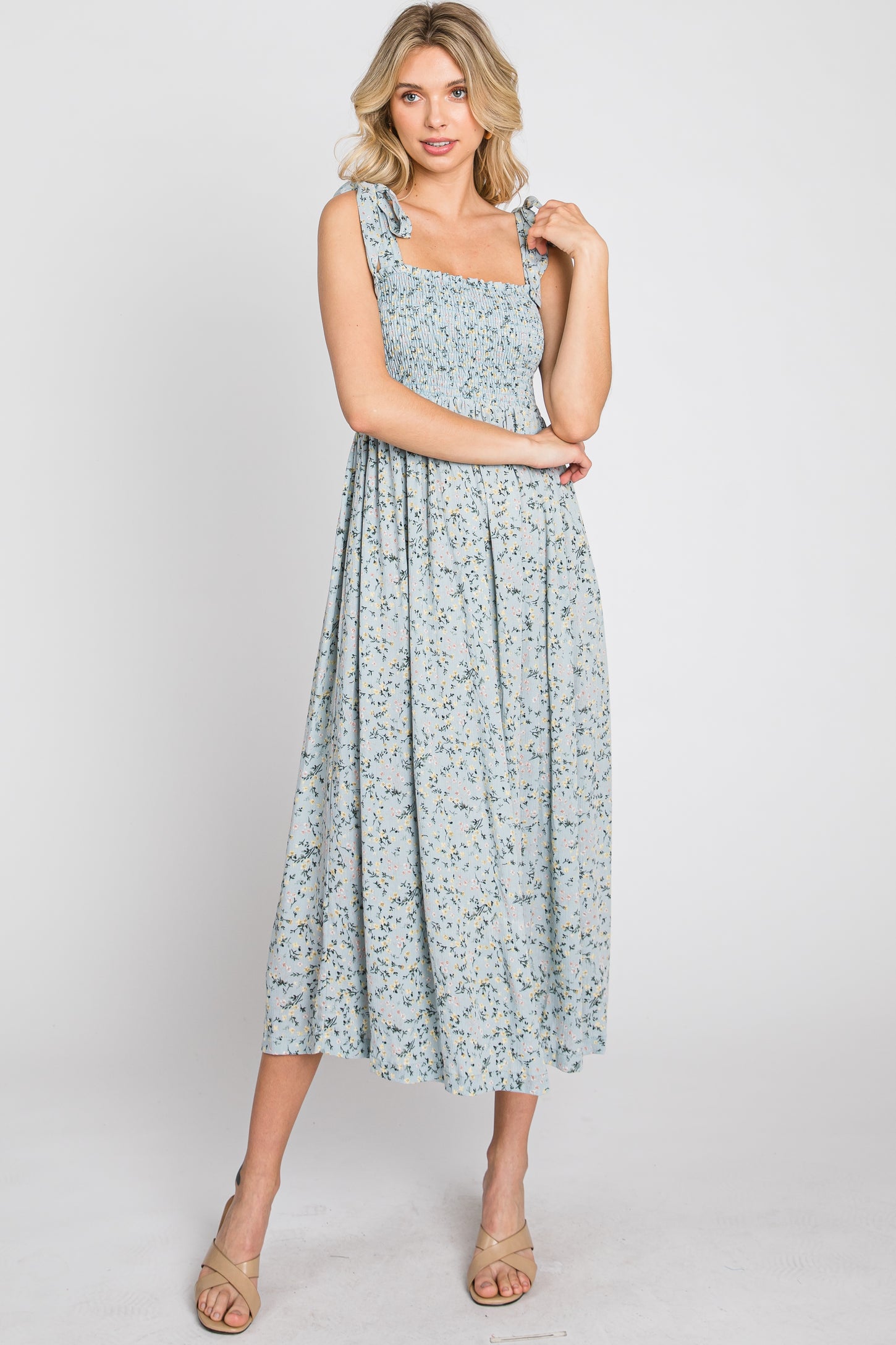 woman wearing a light blue floral maxi dress with smocked bodice and ruffled straps