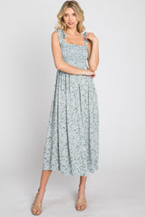 woman wearing a light blue floral maxi dress with smocked bodice and ruffled straps