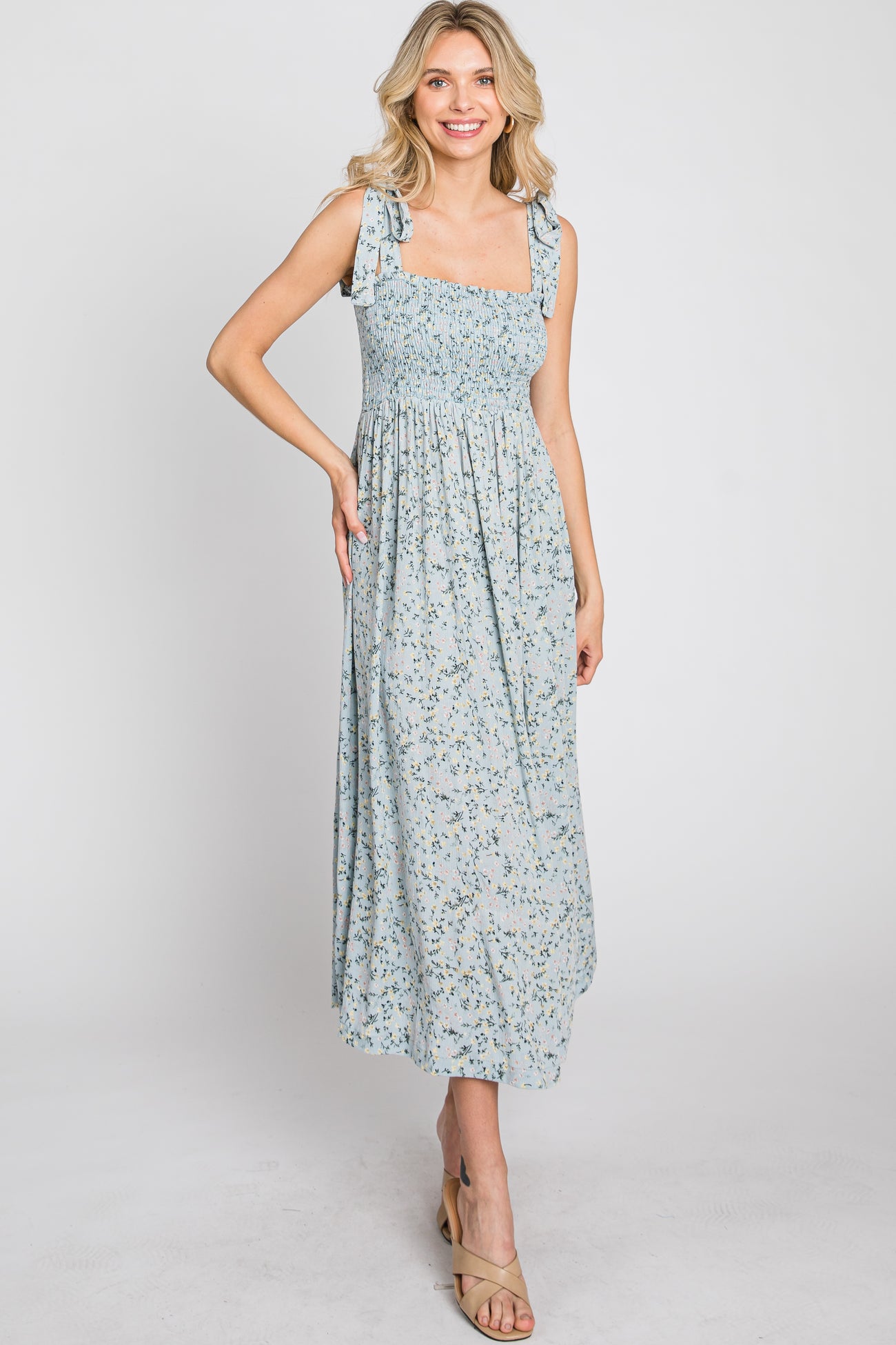 woman wearing a light blue floral maxi dress with square neckline and tie straps