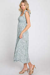 woman wearing a light blue floral midi dress with smocked bodice and ruffle straps