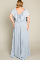 Back view of a woman wearing a light blue plus size maxi dress with a ruffled V-neckline and flowing skirt