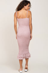 woman wearing a pink ribbed midi dress with ruffle hem and adjustable straps, view from the back