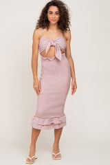 woman wearing a pink gingham smocked midi dress with a front tie cutout and ruffle hem