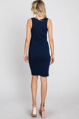 woman wearing a navy blue ribbed sleeveless dress, seen from the back, paired with light-colored block heel sandals