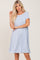 Blonde woman wearing a light blue and white striped short-sleeve t-shirt dress against a plain background
