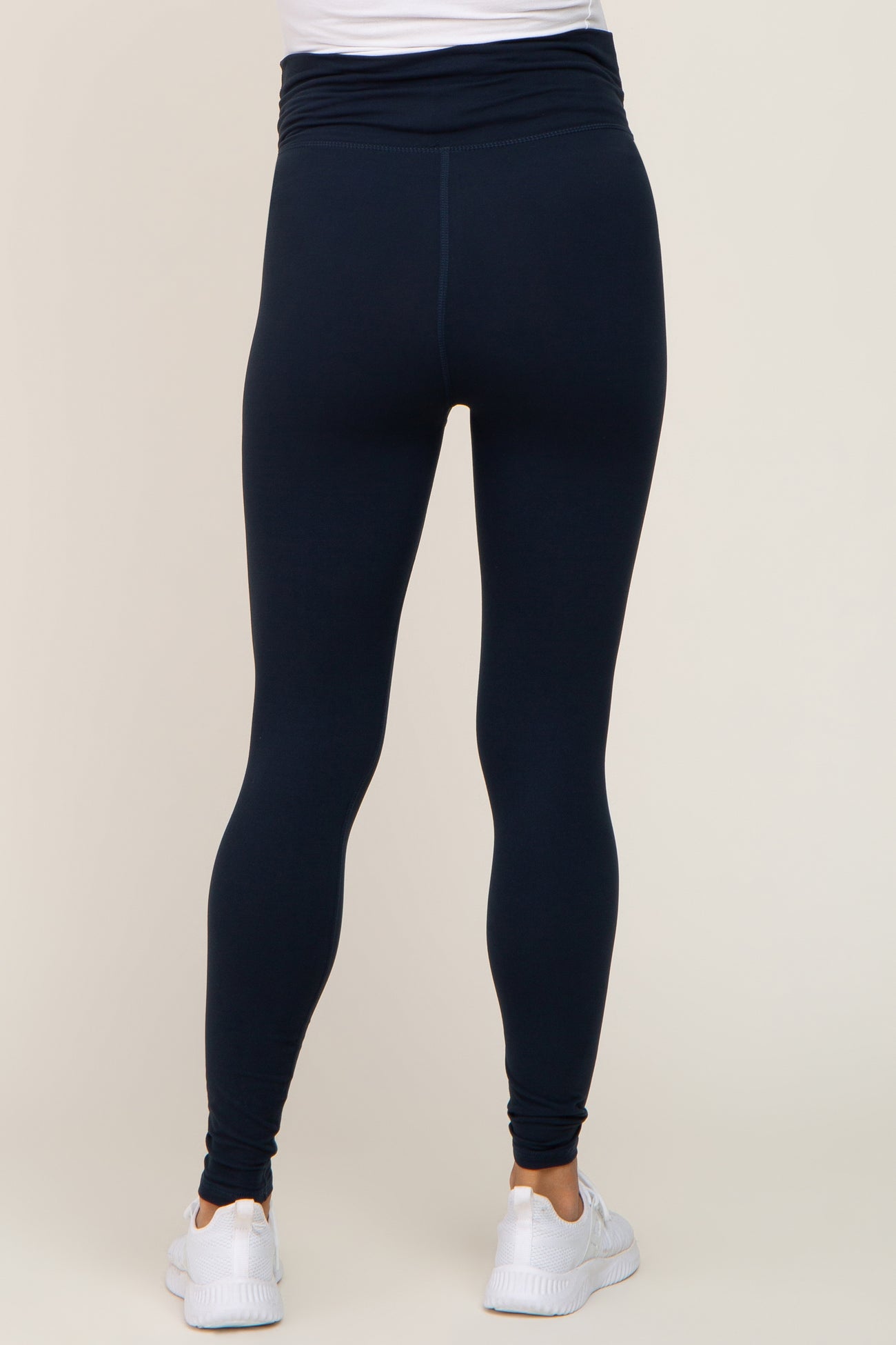woman wearing navy blue maternity leggings with a high waist and a fitted style