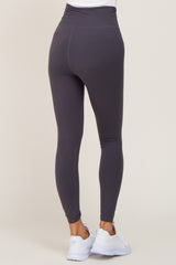 Back view of a person wearing charcoal grey high-waisted leggings and white athletic sneakers