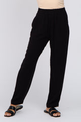 woman wearing black lightweight straight-leg pants with an elastic waist and styled with black sandals