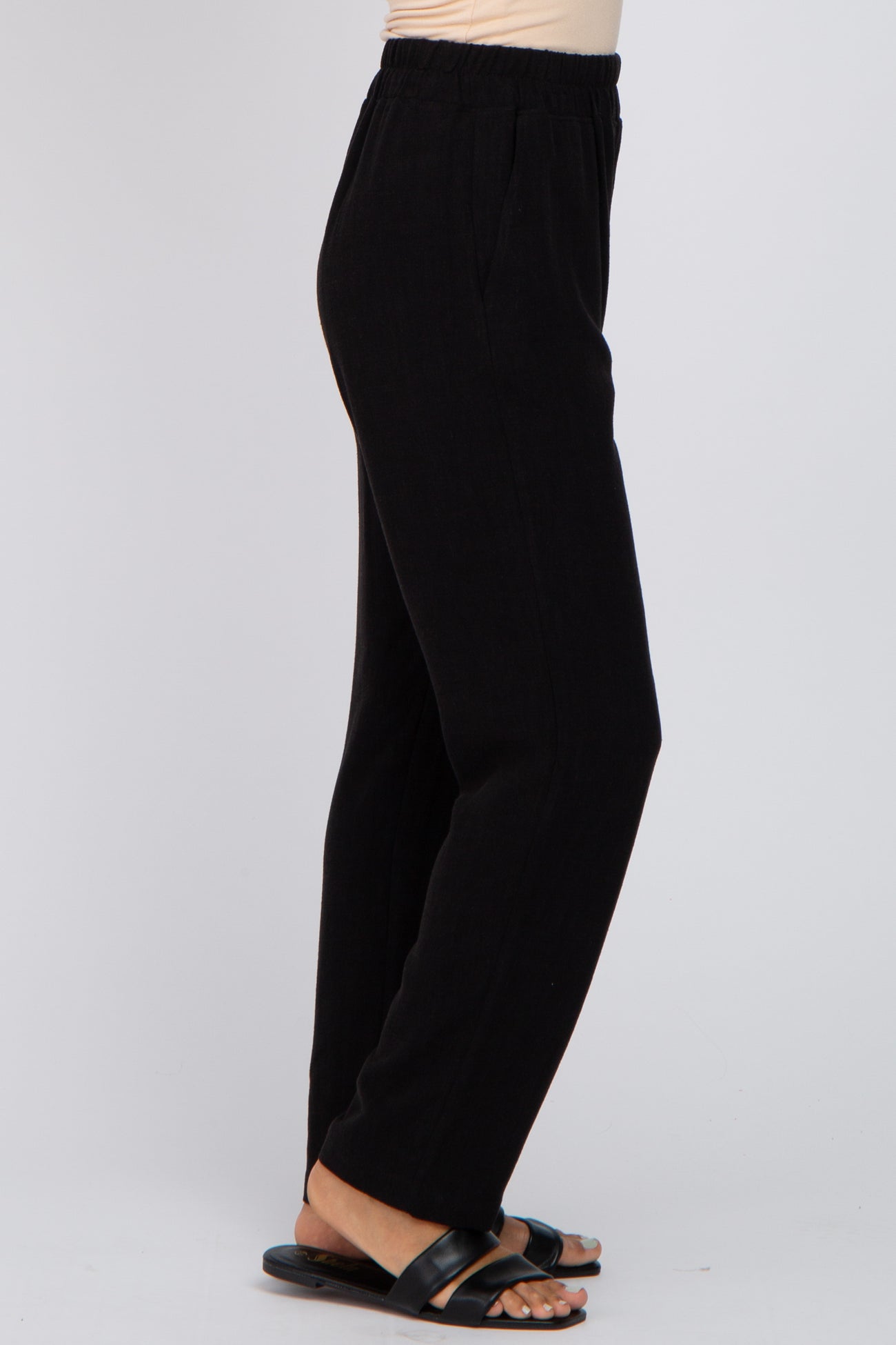 woman wearing black wide-leg trousers with an elastic waistband and side pockets