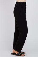 woman wearing black wide-leg trousers with an elastic waistband and side pockets