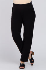 woman wearing black maternity pants with a relaxed fit and side pockets, standing in a pose with one foot forward