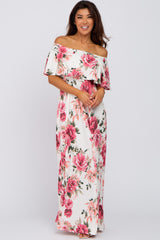 woman wearing a white off-the-shoulder maxi dress with pink floral print and ruffled sleeves