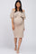 woman wearing a beige off-shoulder maternity dress with ruffle details and a visible baby bump