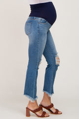woman wearing a pair of light blue distressed maternity jeans with a dark blue belly panel and a visible baby bump