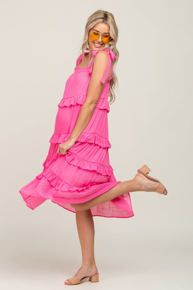 woman in a pink tiered maternity midi dress with tie straps and yellow sunglasses