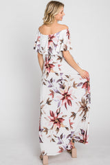 woman wearing a white floral off-the-shoulder maxi dress with ruffle details, showing the back view