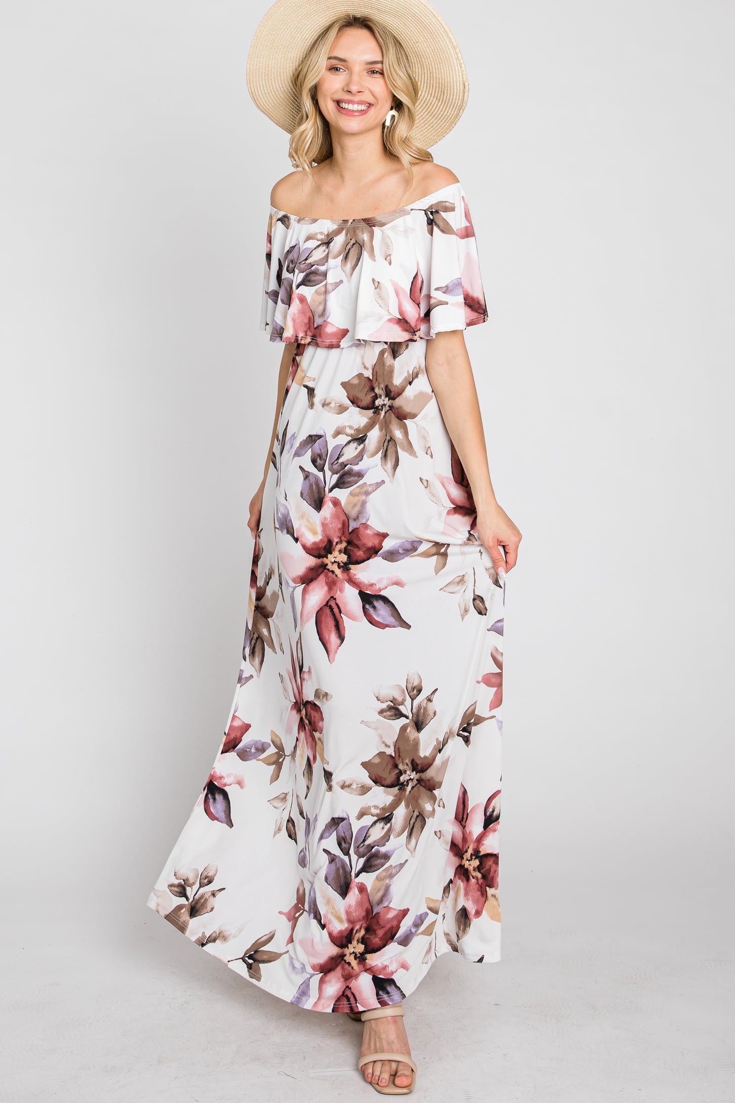 woman wearing a floral off-the-shoulder maxi dress with ruffle detail and a wide-brimmed hat