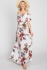 woman wearing a floral off-the-shoulder maxi dress with ruffle detail and a wide-brimmed hat