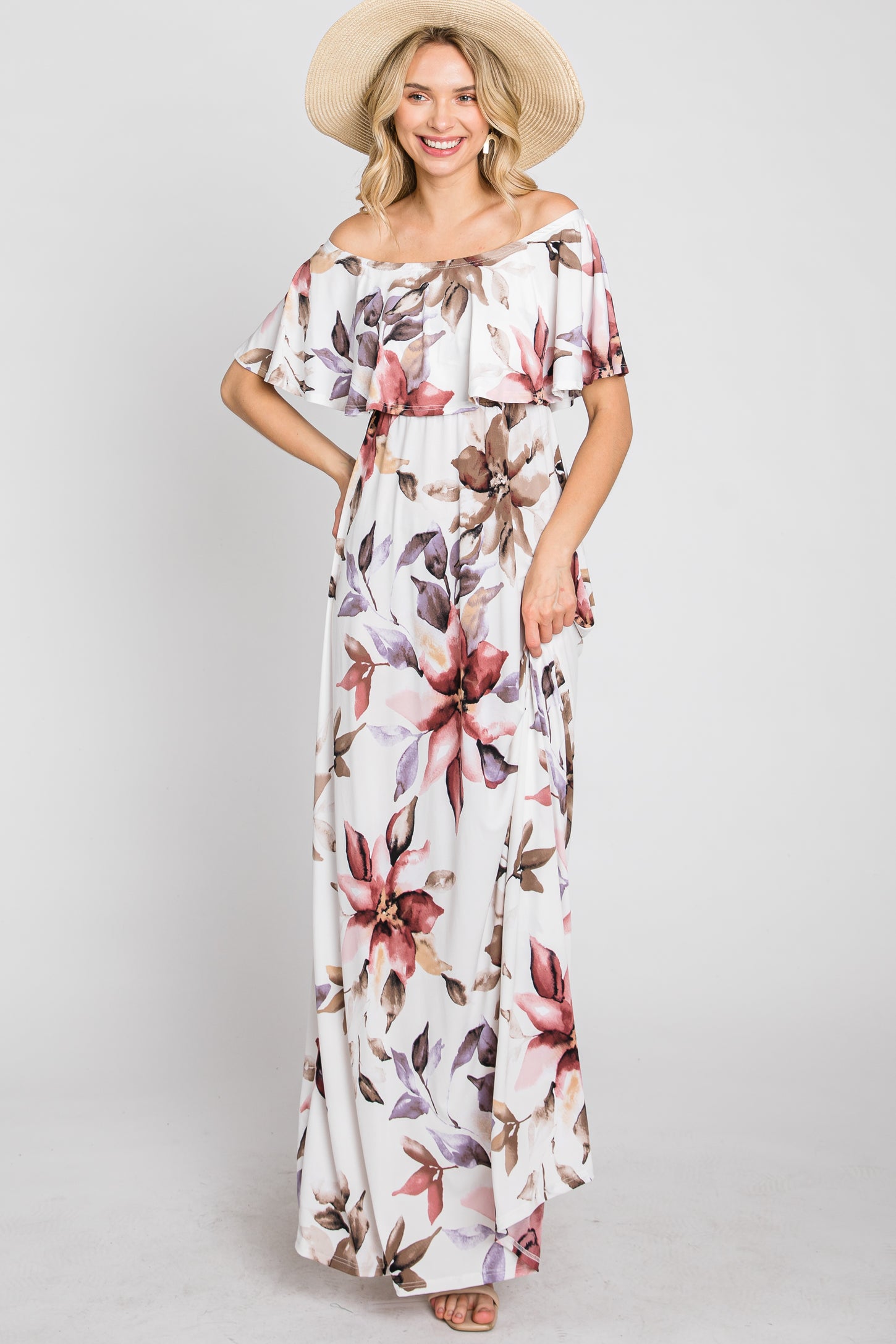 woman wearing a floral off-the-shoulder maxi dress with ruffles and a wide-brimmed straw hat