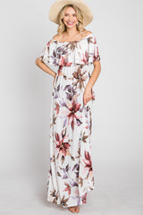woman wearing a floral off-the-shoulder maxi dress with ruffles and a wide-brimmed straw hat