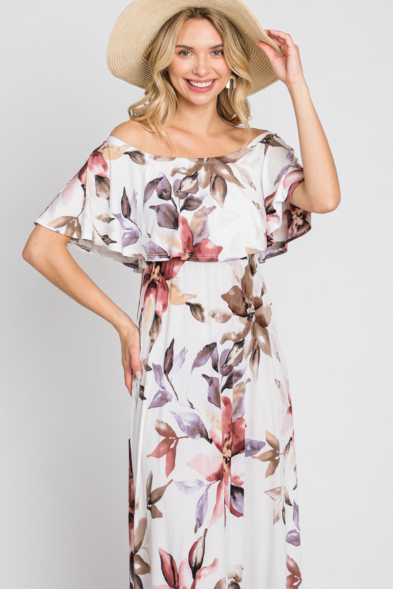 woman wearing a floral off-the-shoulder maxi dress with a flowy design and a wide-brimmed straw hat