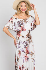 woman wearing a floral off-the-shoulder maxi dress with a flowy design and a wide-brimmed straw hat