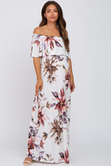 woman wearing a floral off-the-shoulder maxi dress, showcasing a baby bump, in a light color palette with pink and purple accents