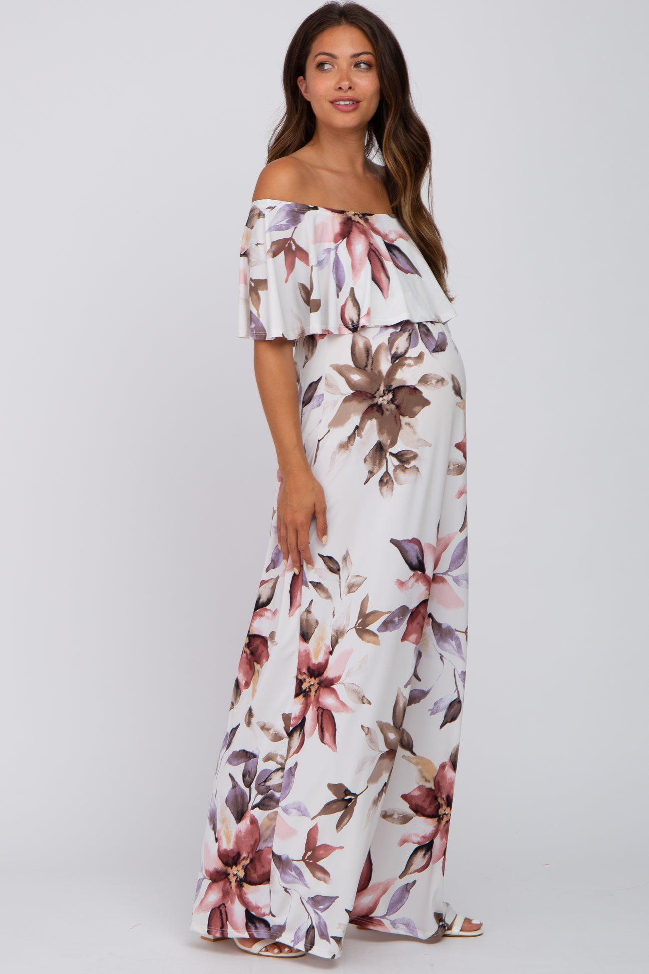 woman wearing a floral off-the-shoulder maternity maxi dress with a flowing design and visible baby bump