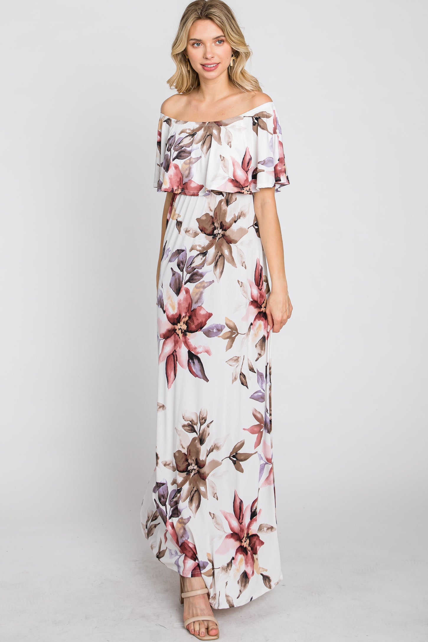 woman wearing a floral off-the-shoulder maxi dress with pink and purple flowers on a white background