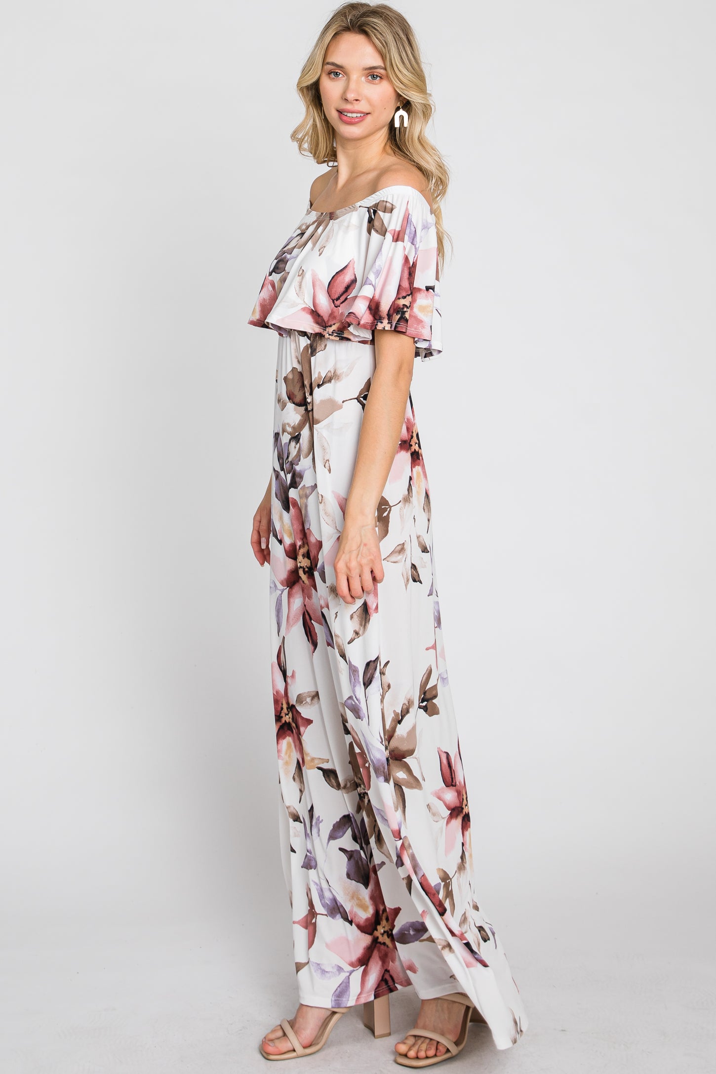 woman wearing a floral off-the-shoulder maxi dress with ruffle sleeves and a straight silhouette, standing sideways