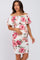 woman wearing a white floral off-the-shoulder maternity dress with ruching and a visible baby bump