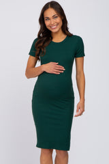 Smiling pregnant woman wearing a short sleeve dark green ribbed maternity midi dress