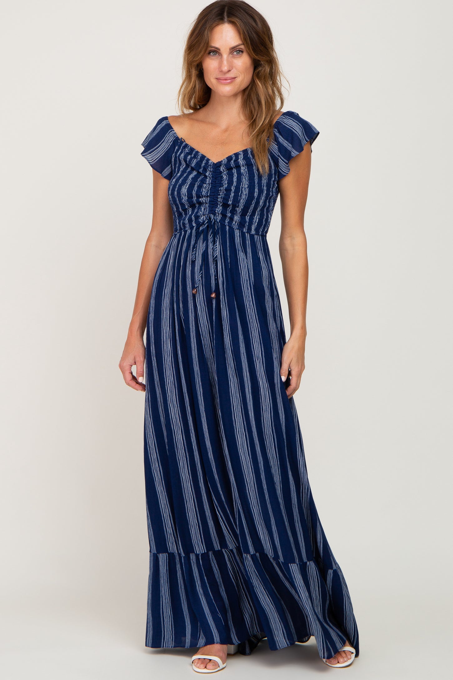woman wearing a navy blue and white striped maternity maxi dress with ruffled sleeves and a cinched waist