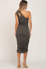 woman from behind wearing a one-shoulder floral midi dress with ruched detailing and tan heels