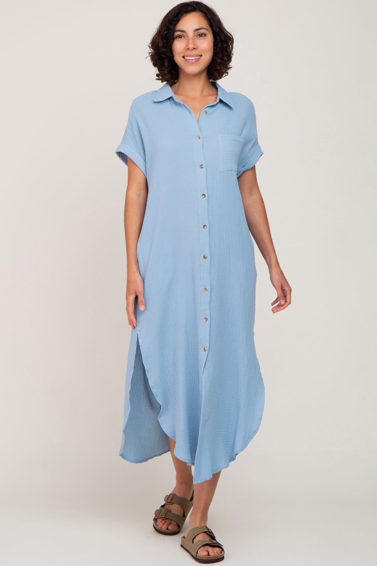 woman wearing a light blue button-up midi shirt dress with short sleeves and a side slit