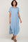 woman wearing a light blue button-up midi shirt dress with short sleeves and a side slit