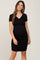 pregnant woman wearing a black short sleeve maternity dress with a crossover neckline and ruched sides