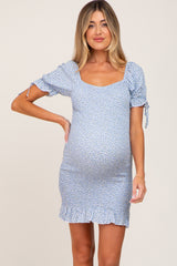pregnant woman wearing a light blue floral smocked maternity dress with puff sleeves