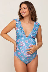 woman wearing a blue floral maternity swimsuit with ruffled sleeves and showing her baby bump
