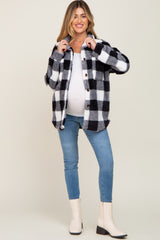 smiling pregnant woman wearing black and white buffalo plaid sherpa jacket with blue jeans and cream boots