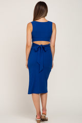 woman wearing a blue ribbed maternity two-piece dress with a fitted crop top and tie detail at the back